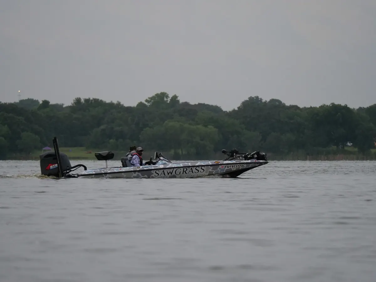 Fishing boat running across a calm lake